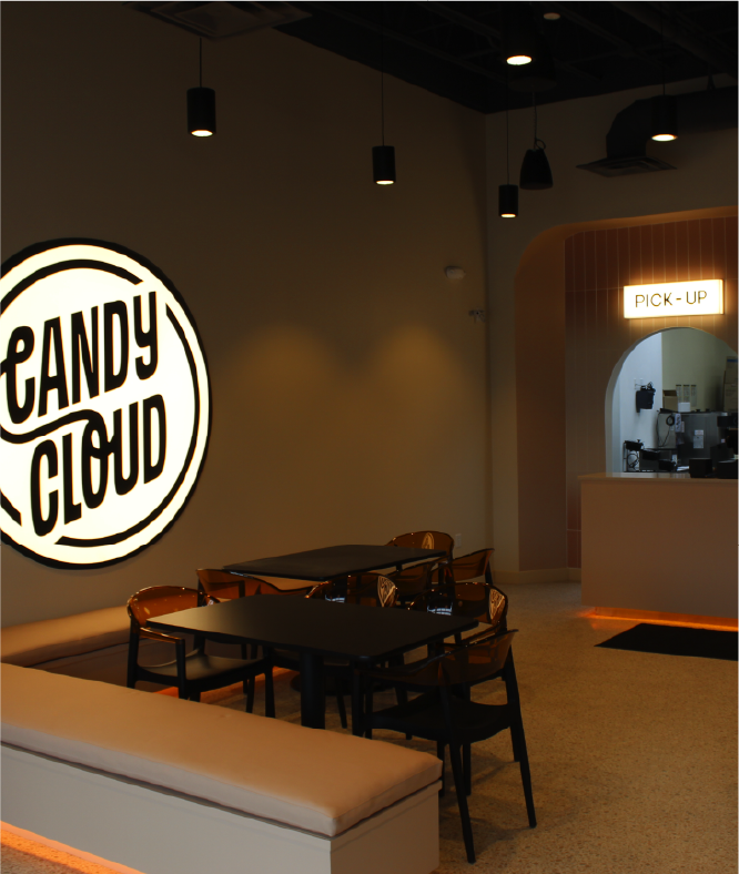 Modern Candy Cloud shop interior with seating area and illuminated pickup counter.