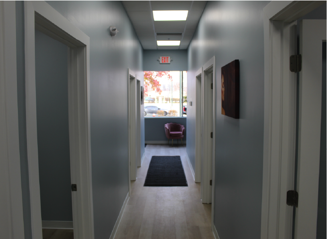 Renovated commercial office hallway with private rooms and modern finishes.